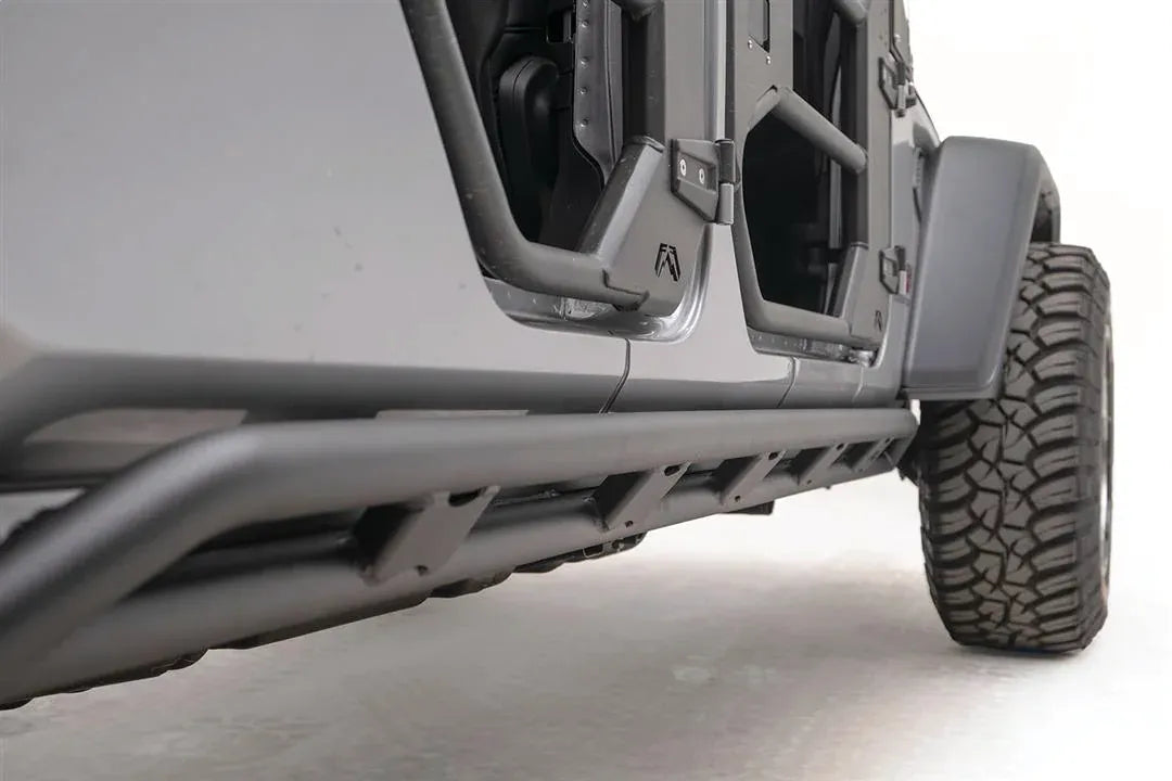 Fab Fours tube rock slider on a silver Jeep Gladiator, low passenger-side view, showing the matte black tube rail 