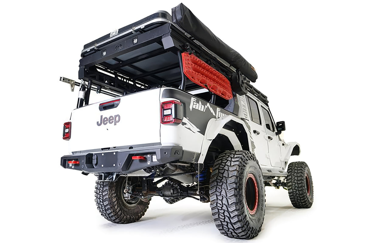 Fab Fours standard rear bumper on a lifted white Jeep Gladiator with Fab Fours graphics and overland bed rack, passenger-side rear three-quarter view