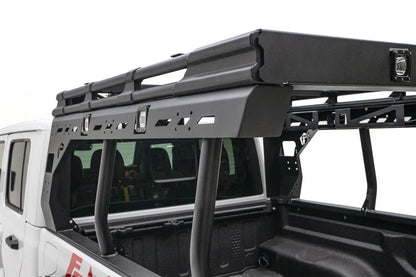 Close-up of the Fab Fours Overland Bed Rack driver-side rail on a white Jeep Gladiator, showing the slotted mounting panel, integrated cube lights and tubular uprights