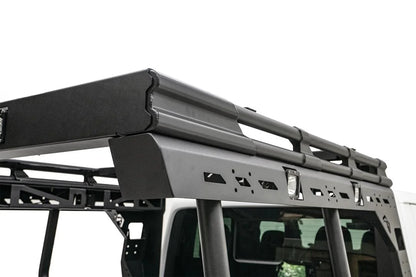Close-up of the Fab Fours Overland Bed Rack passenger-side rail on a Jeep Gladiator, showing the slotted mounting panel, integrated cube lights and tubular uprights