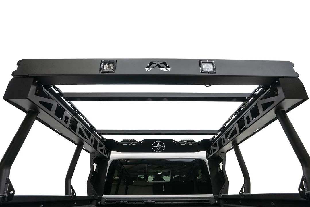 Fab Fours Overland Bed Rack on a Jeep Gladiator, rear view from the bed, showing the logo-cut rear bar with two cube lights, cross-members and cross-braced side frames