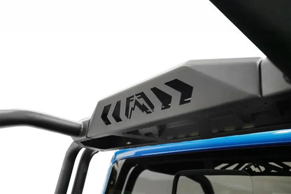 Close-up of the Fab Fours sport rack center panel with Fab Fours logo and chevron cutouts behind the cab of a blue Jeep Gladiator