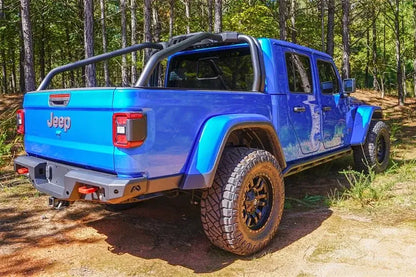 Fab Fours sport rack on a lifted blue Jeep Gladiator in the woods, passenger-side rear three-quarter view