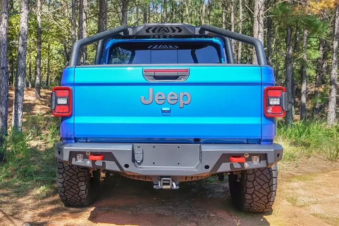 Fab Fours sport rack on a blue Jeep Gladiator in the woods, straight rear view, with Fab Fours rear bumper