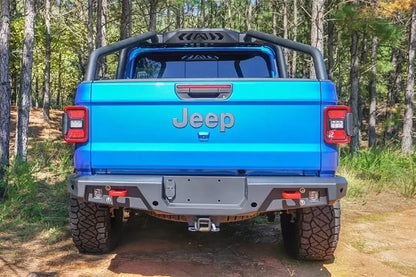 Fab Fours sport rack on a blue Jeep Gladiator in the woods, straight rear view, with Fab Fours rear bumper