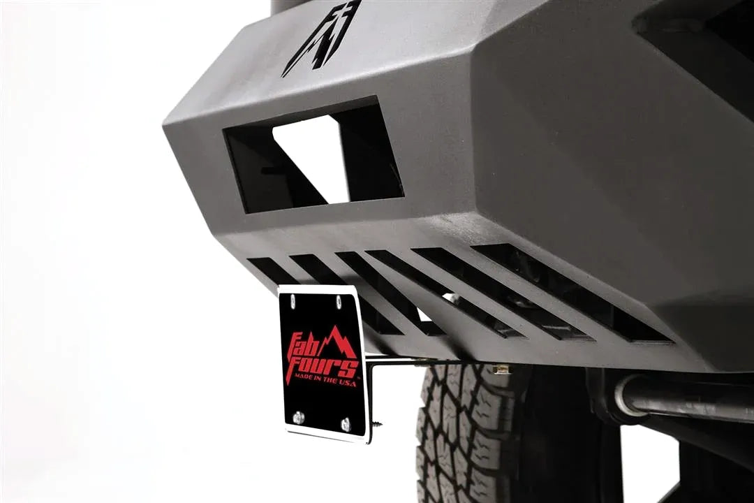 Angled close-up of Fab Fours license plate bracket mounted under the corner of a Vengeance front bumper