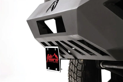Angled close-up of Fab Fours license plate bracket mounted under the corner of a Vengeance front bumper
