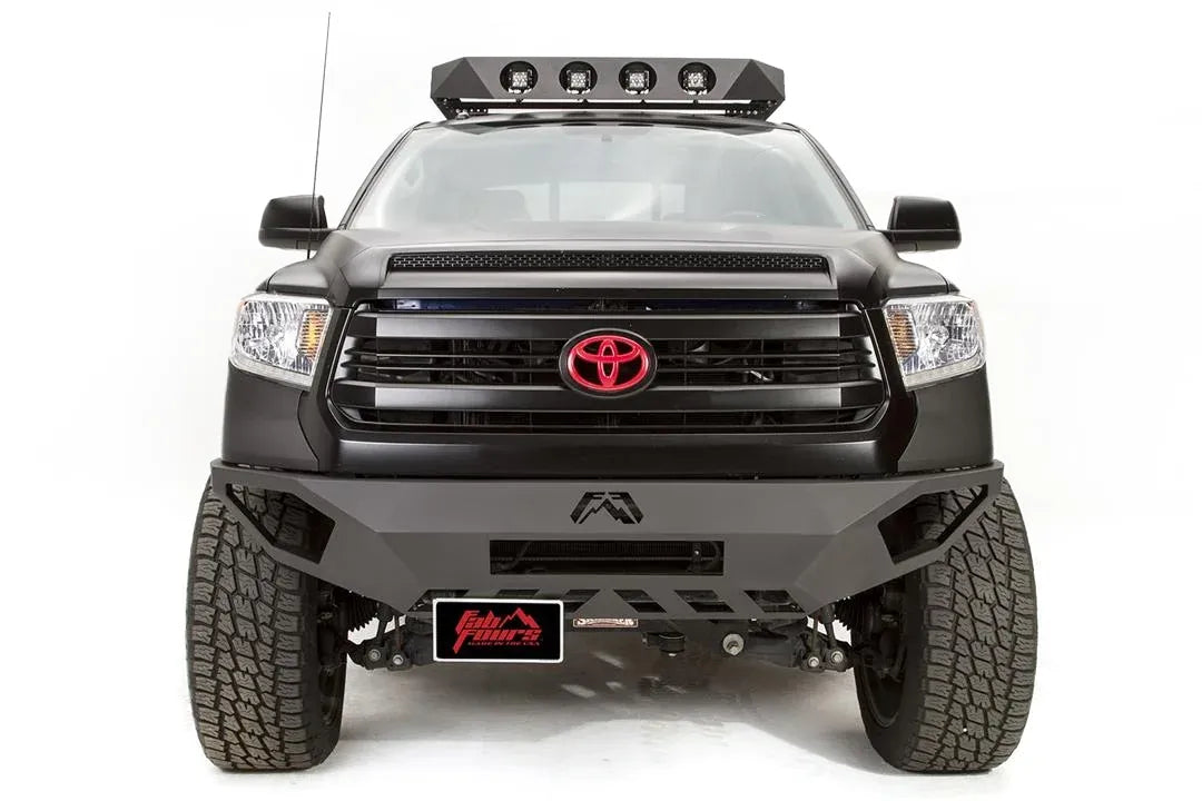 Fab Fours Vengeance front bumper on a black Toyota Tundra, front view, with license plate bracket mounted below the bumper, offset to the passenger side