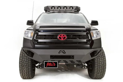 Fab Fours Vengeance front bumper on a black Toyota Tundra, front view, with license plate bracket mounted below the bumper, offset to the passenger side