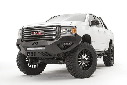 Black honeycomb mesh insert covers in the side light openings of a Fab Fours Vengeance front bumper on a lifted white GMC Canyon, driver-side front three-quarter view