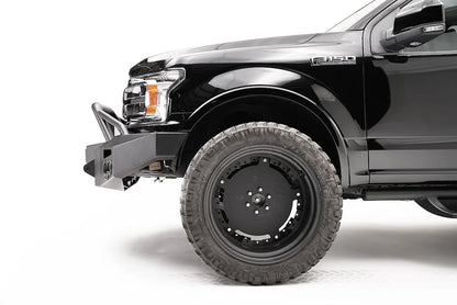 Fab Fours Premium winch front bumper with pre-runner guard on a black Ford F-150, driver-side profile view of the bumper end and front wheel