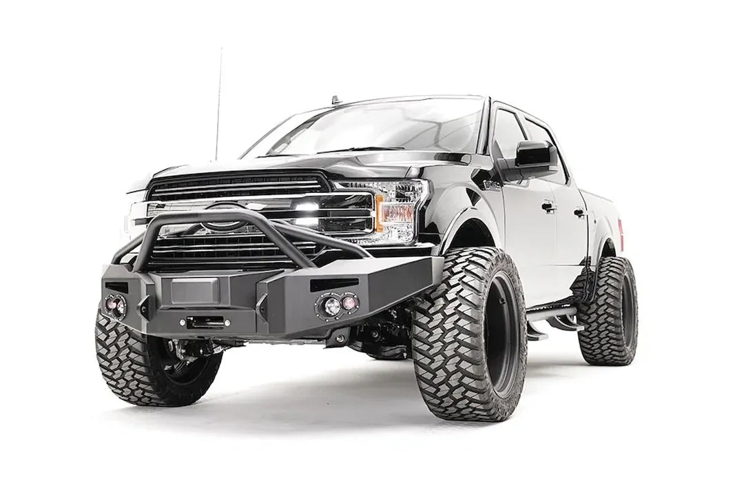 Fab Fours adaptive cruise control relocation bracket in a Fab Fours Premium winch front bumper with pre-runner guard on a lifted black Ford F-150, driver-side front three-quarter view