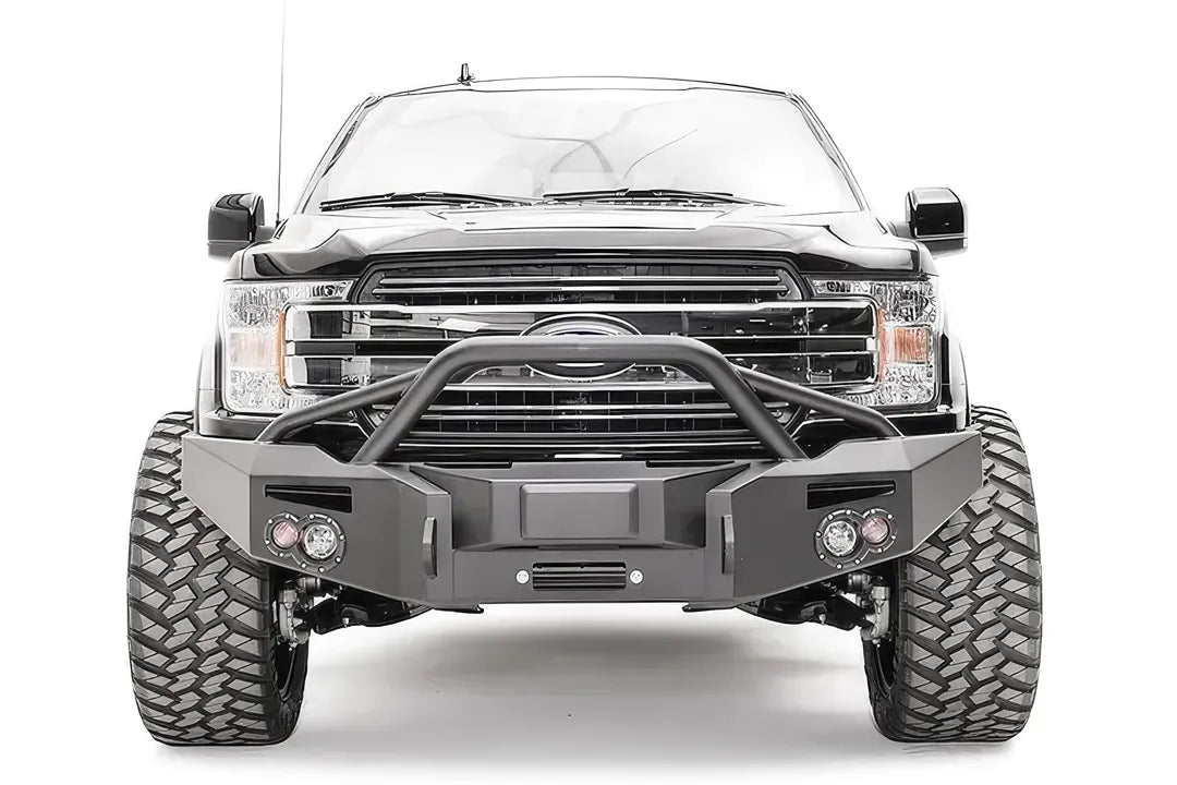 Fab Fours adaptive cruise control relocation bracket centered in a Fab Fours Premium winch front bumper with pre-runner guard on a black Ford F-150, front view