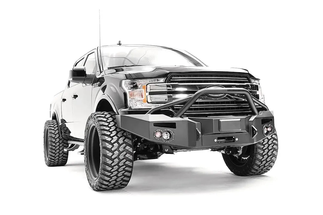Fab Fours adaptive cruise control relocation bracket in a Fab Fours Premium winch front bumper with pre-runner guard on a lifted black Ford F-150, passenger-side front three-quarter view