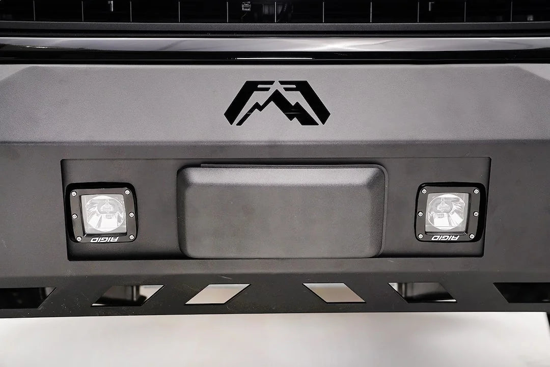 Straight-on close-up of Fab Fours adaptive cruise control relocation bracket holding the Ford F-150 radar sensor, centered below the Fab Fours logo between two cube lights