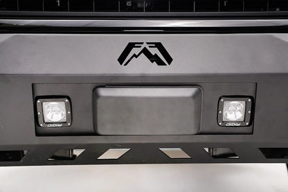 Straight-on close-up of Fab Fours adaptive cruise control relocation bracket holding the Ford F-150 radar sensor, centered below the Fab Fours logo between two cube lights