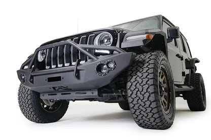 Fab Fours sway bar cover on a black Jeep Wrangler JL, low front driver-side view, showing the slotted steel cover protecting the front sway bar below a Fab Fours front bumper
