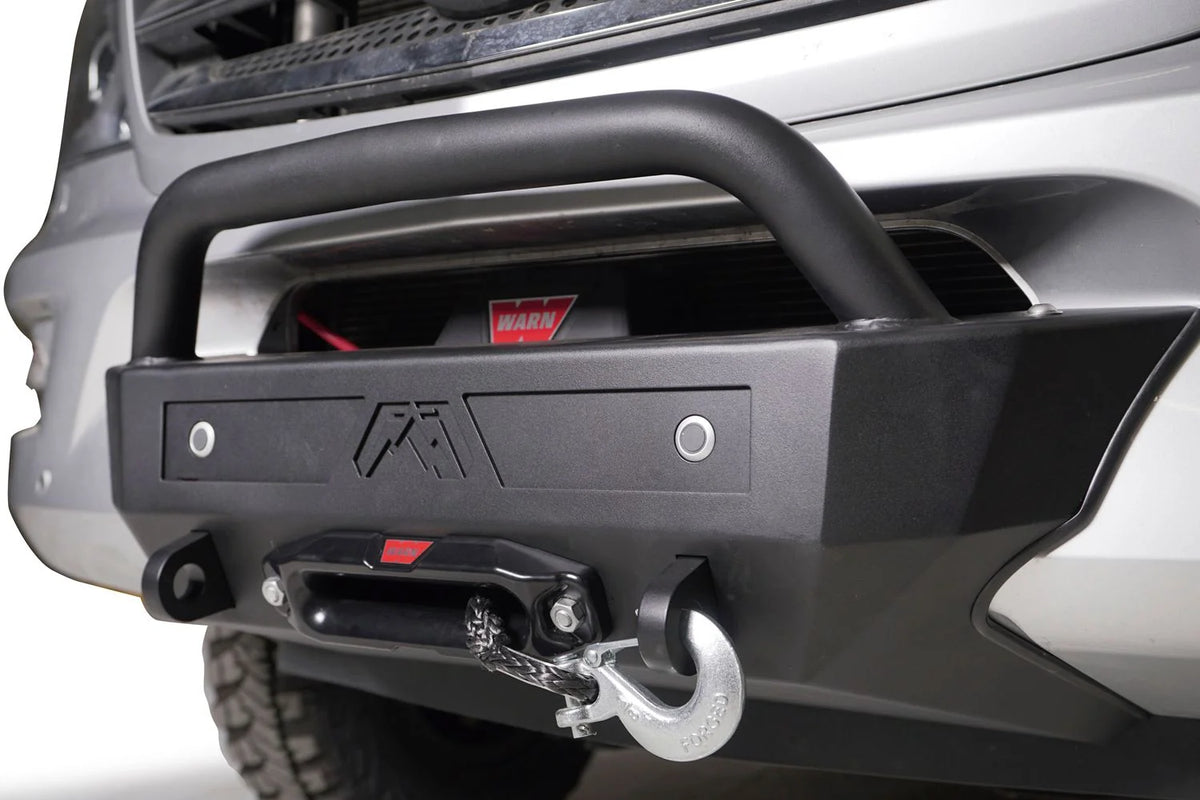 Fab Fours sensor plate with two parking sensors mounted on a front bumper with pre-runner guard and Warn winch on a silver truck, angled view