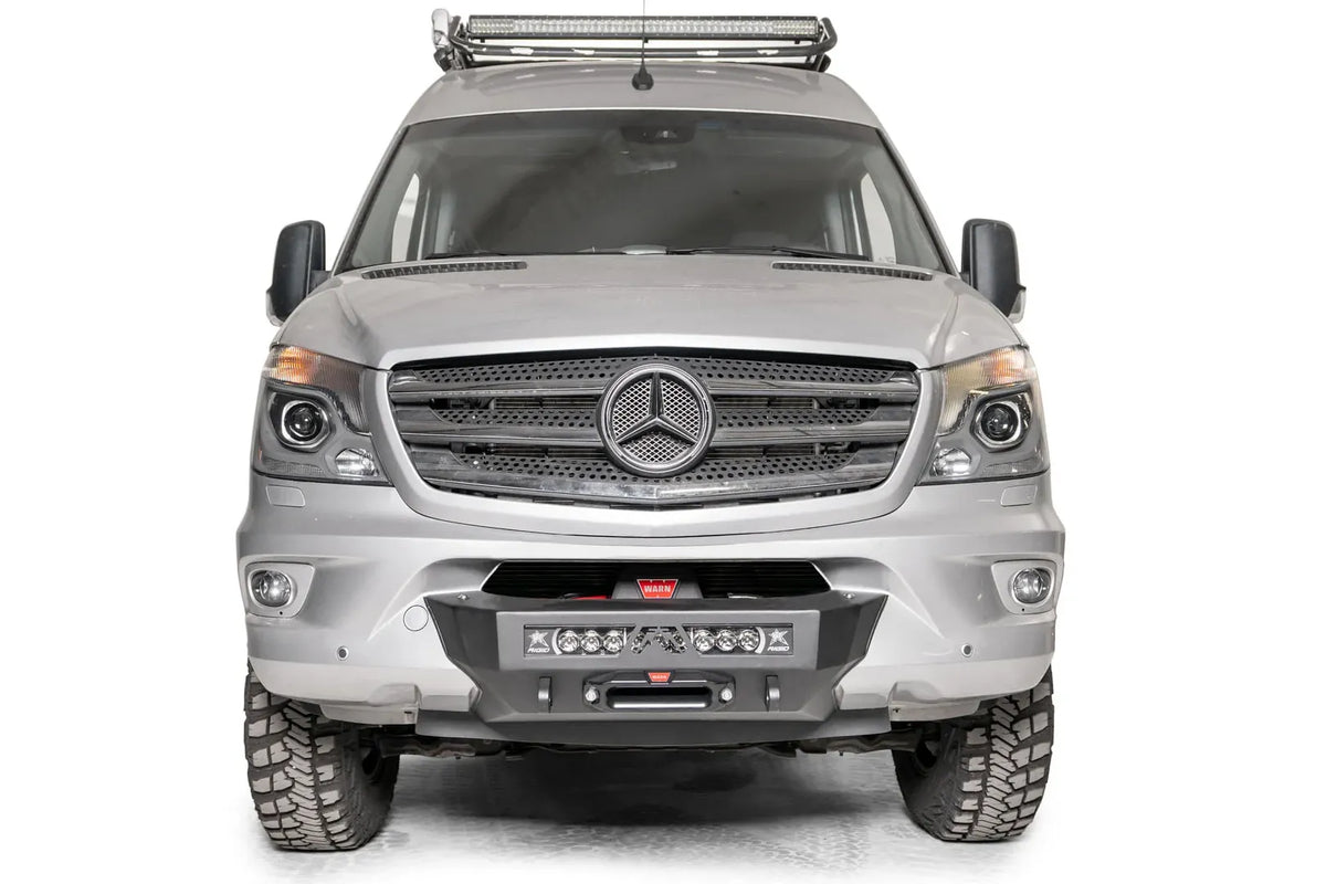 Fab Fours semi-hidden winch mount on a silver Mercedes-Benz Sprinter, straight-on front view, showing the low-profile winch plate, integrated light bar and fairlead