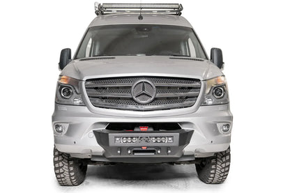 Fab Fours semi-hidden winch mount on a silver Mercedes-Benz Sprinter, straight-on front view, showing the low-profile winch plate, integrated light bar and fairlead