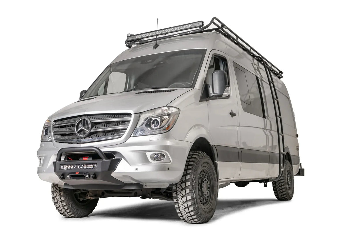 Fab Fours semi-hidden winch mount with pre-runner guard on a silver Mercedes-Benz Sprinter, driver-side front three-quarter view, showing the tube hoop and low-profile winch plate