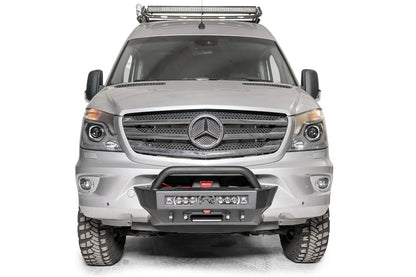 Fab Fours semi-hidden winch mount with pre-runner guard on a silver Mercedes-Benz Sprinter, straight-on front view, showing the tube hoop, light bar and fairlead