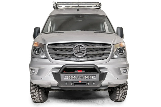 Fab Fours semi-hidden winch mount with pre-runner guard on a silver Mercedes-Benz Sprinter, straight-on front view, showing the tube hoop, light bar and fairlead