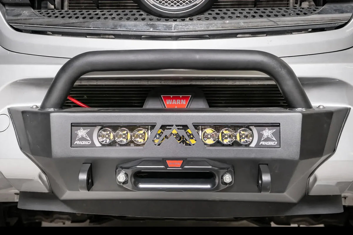 Fab Fours semi-hidden winch mount with pre-runner guard on a silver Mercedes-Benz Sprinter, close front view, showing the tube hoop, winch, light bar and fairlead