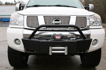 Fab Fours winch mount on a white Nissan TITAN outdoors, straight-on front view, showing the tube hoop, winch and roller fairlead