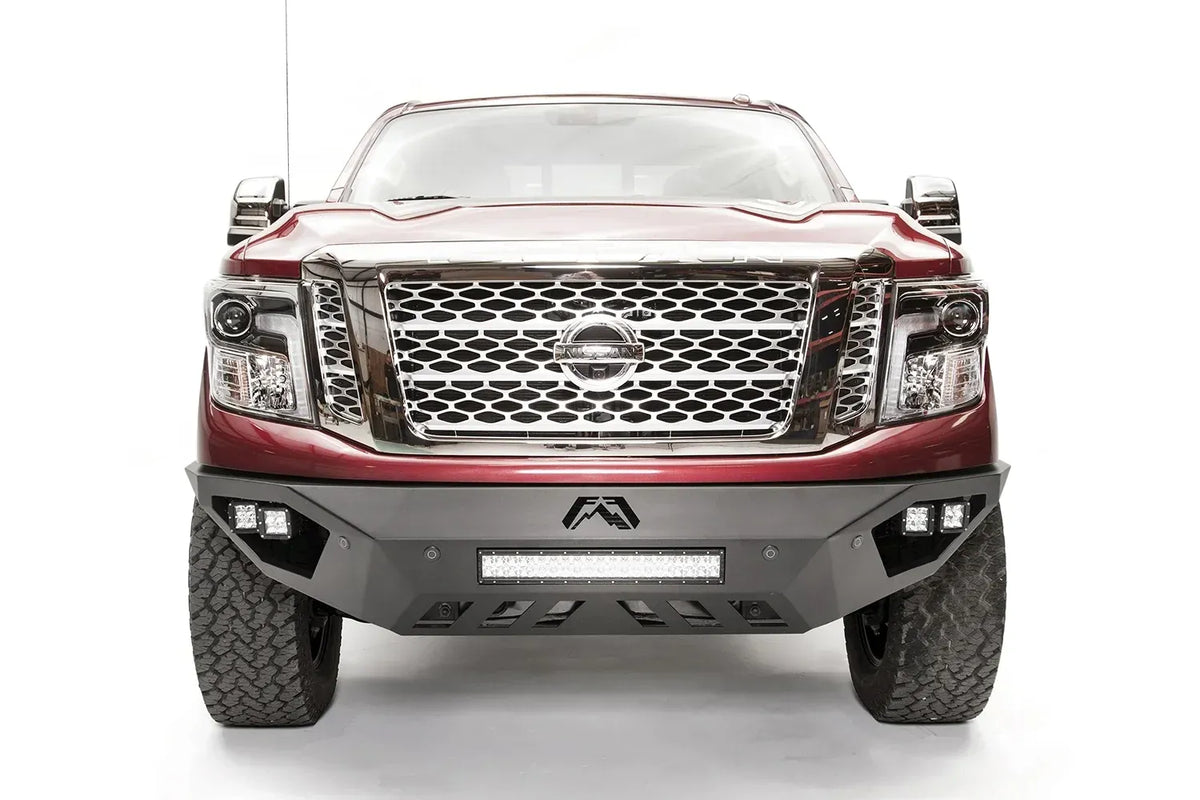 Fab Fours Vengeance front bumper on a red Nissan TITAN XD, straight-on front view, showing the center LED light bar, cube lights and lower skid plate