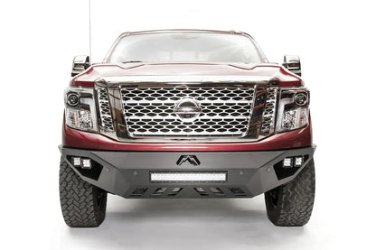 Fab Fours Vengeance front bumper on a red Nissan TITAN XD, straight-on front view, showing the center LED light bar, cube lights and lower skid plate