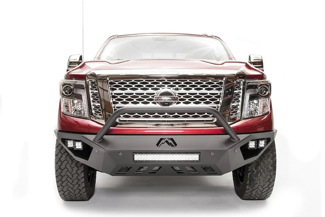 Fab Fours Vengeance front bumper with pre-runner guard on a red Nissan TITAN XD, straight-on front view, showing the tube hoop, center LED light bar and skid plate
