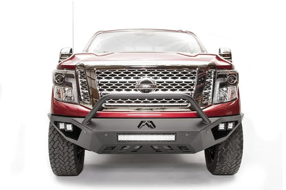 Fab Fours Vengeance front bumper with pre-runner guard on a red Nissan TITAN XD, straight-on front view, showing the tube hoop, center LED light bar and skid plate