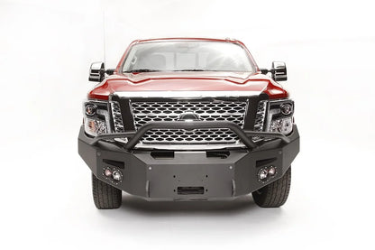 Fab Fours Premium front bumper with pre-runner guard on a red Nissan TITAN XD, straight-on front view, showing the tube hoop, centered winch opening and round fog lights