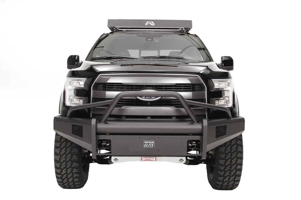 Fab Fours Elite front guard plate on a black Ford F-150, straight-on front view, shown in the center of an Elite bumper with pre-runner guard and mesh light openings