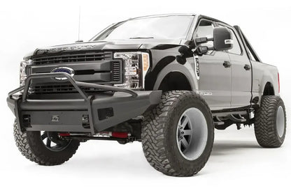 Fab Fours Elite front guard plate on a black Ford Super Duty, driver-side front three-quarter view, shown in an Elite bumper with pre-runner guard and mesh light openings