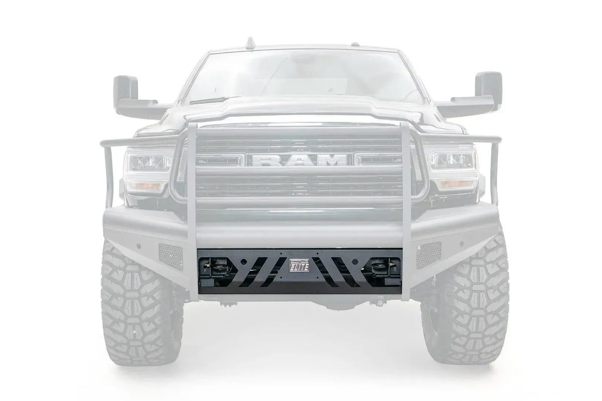 Fab Fours Elite replacement lower guard on a Ram 2500/3500 with an Elite front bumper and full grille guard, straight-on front view, with the guard highlighted in black against a faded truck, showing the angled slot cut-outs, Elite badge and shackle mount openings