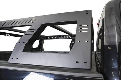 Close-up of the Fab Fours Adjustable Overland Rack side panel on a black pickup, showing the large cutout window, slotted mounting points and vented crossbars