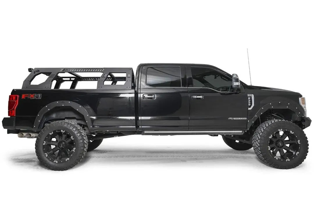 Fab Fours Adjustable Overland Rack on a black full-size pickup truck, passenger-side profile, showing the low-profile rack sitting flush over the bed behind the cab