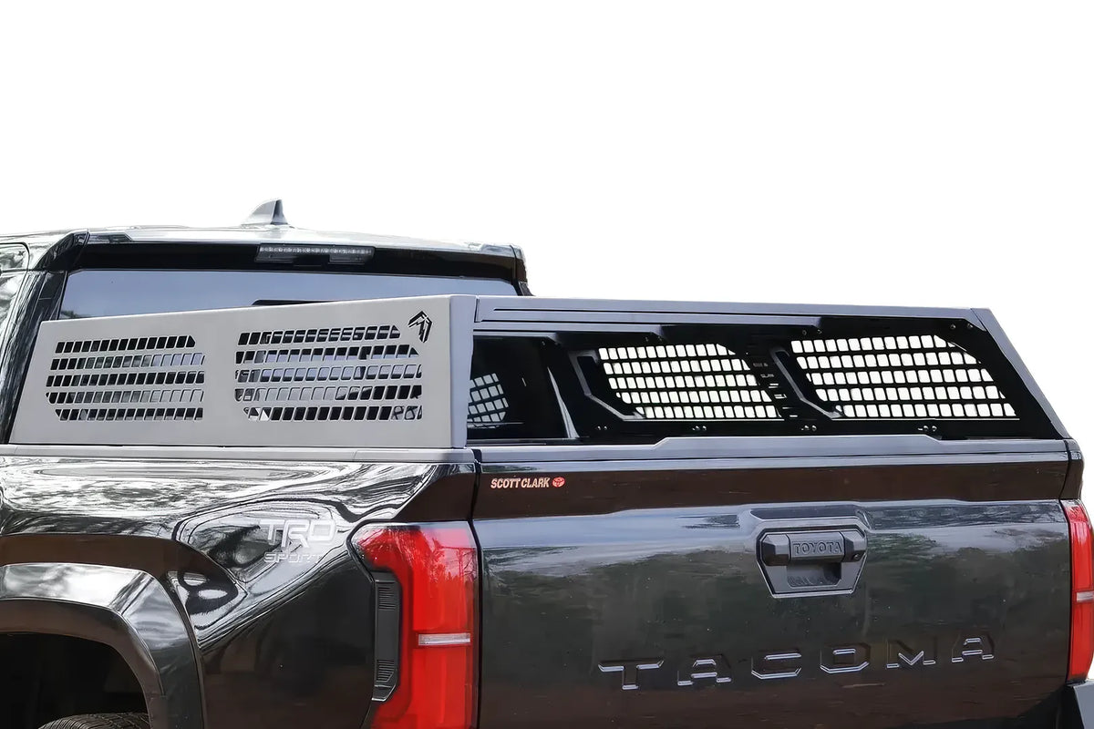 Fab Fours half rack with perforated side panels and mesh bed panels on a black Toyota Tacoma, driver-side rear view