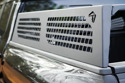 Close-up of a Fab Fours half rack side panel with perforated cutouts and Fab Fours logo along the bed rail of a Toyota Tacoma