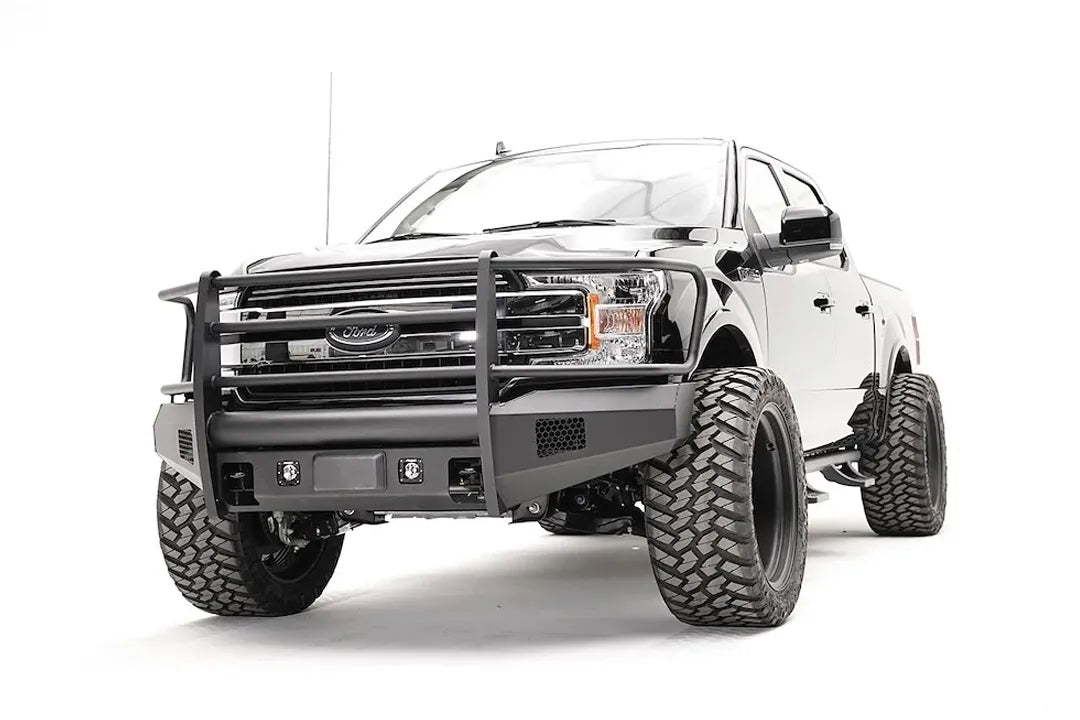 Fab Fours Elite adaptive cruise control relocation bracket on a black Ford F-150, driver-side front three-quarter view, showing the sensor plate in an Elite bumper with full guard