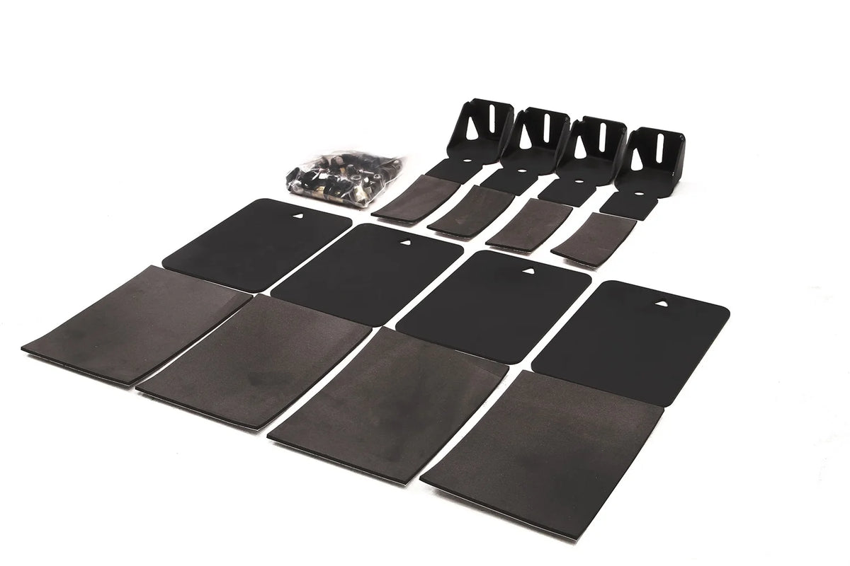 Fab Fours soft roof helper kit laid out on a white background, including four black mounting brackets, four steel plates with foam pads, foam strips, and a bag of hardware