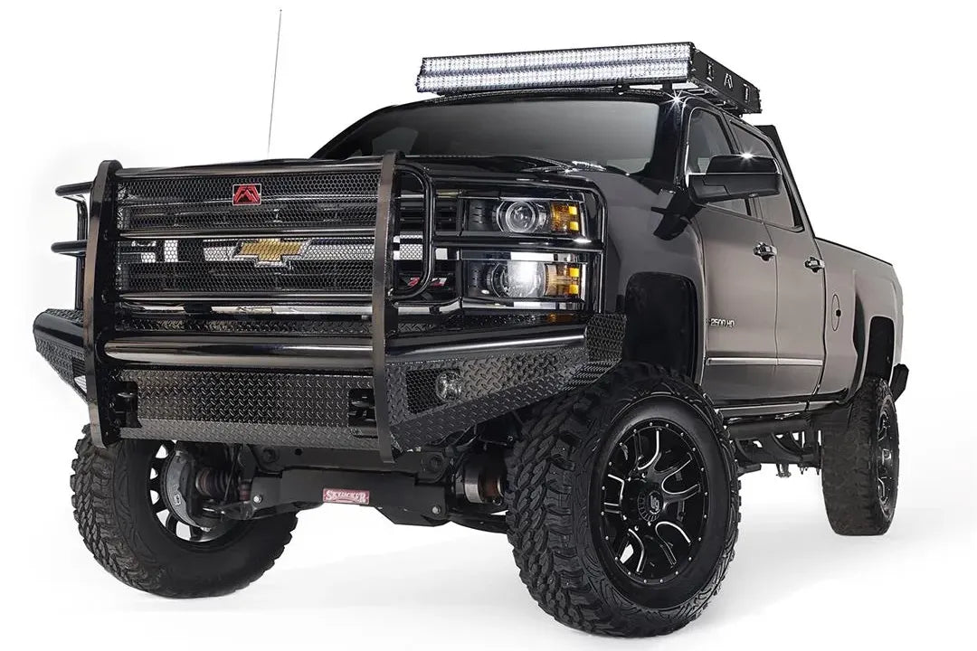 Fab Fours roof rack on a black Chevrolet Silverado HD, driver-side front three-quarter view, showing the rack with light bar on the cab roof