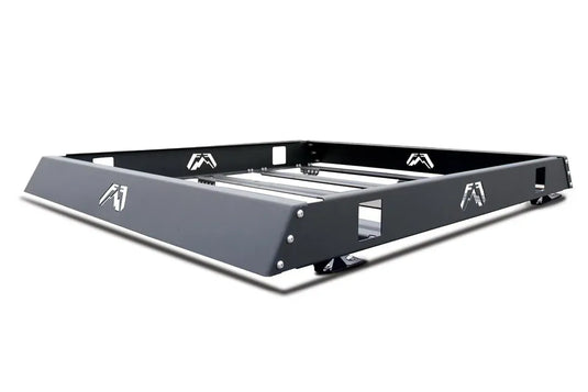 Fab Fours roof rack in black powder coat, angled view, showing the open basket frame, crossbars, logo cutouts and mounting feet
