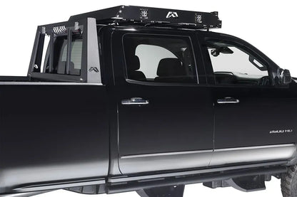 Fab Fours roof rack on a black Chevrolet Silverado HD, passenger-side view, showing the rack mounted above the cab with logo cutouts and cube lights
