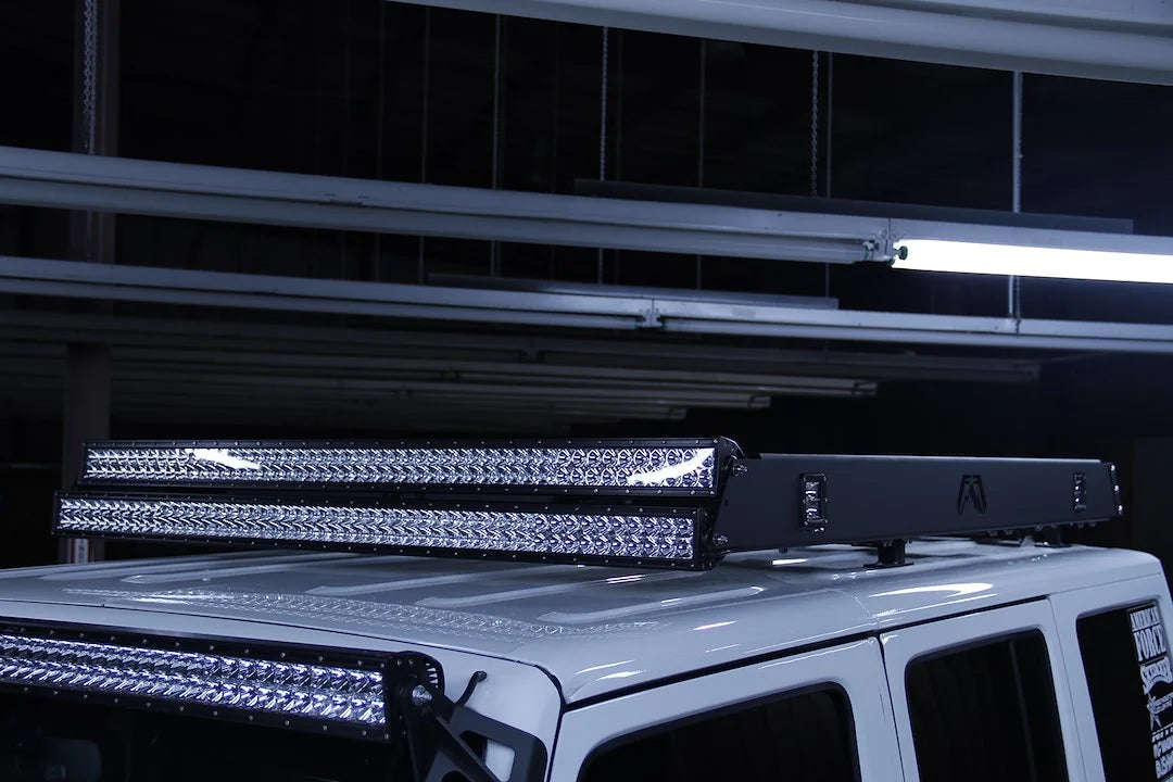 Fab Fours roof rack on a white Jeep Wrangler JK, close-up view, showing the rack edge with front-mounted LED light bars
