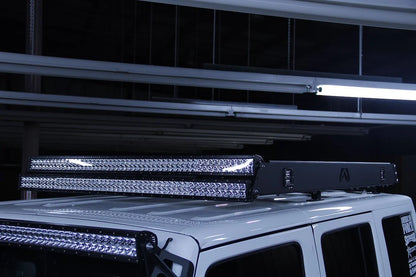 Fab Fours roof rack on a white Jeep Wrangler JK, close-up view, showing the rack edge with front-mounted LED light bars