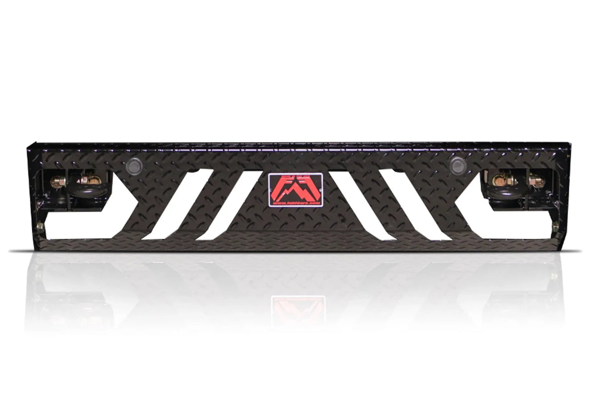 Fab Fours replacement lower guard for Chevrolet Silverado, black diamond tread plate panel with angled cutouts, two sensor holes, D-ring shackles on each end and a red Fab Fours badge in the center on a white background