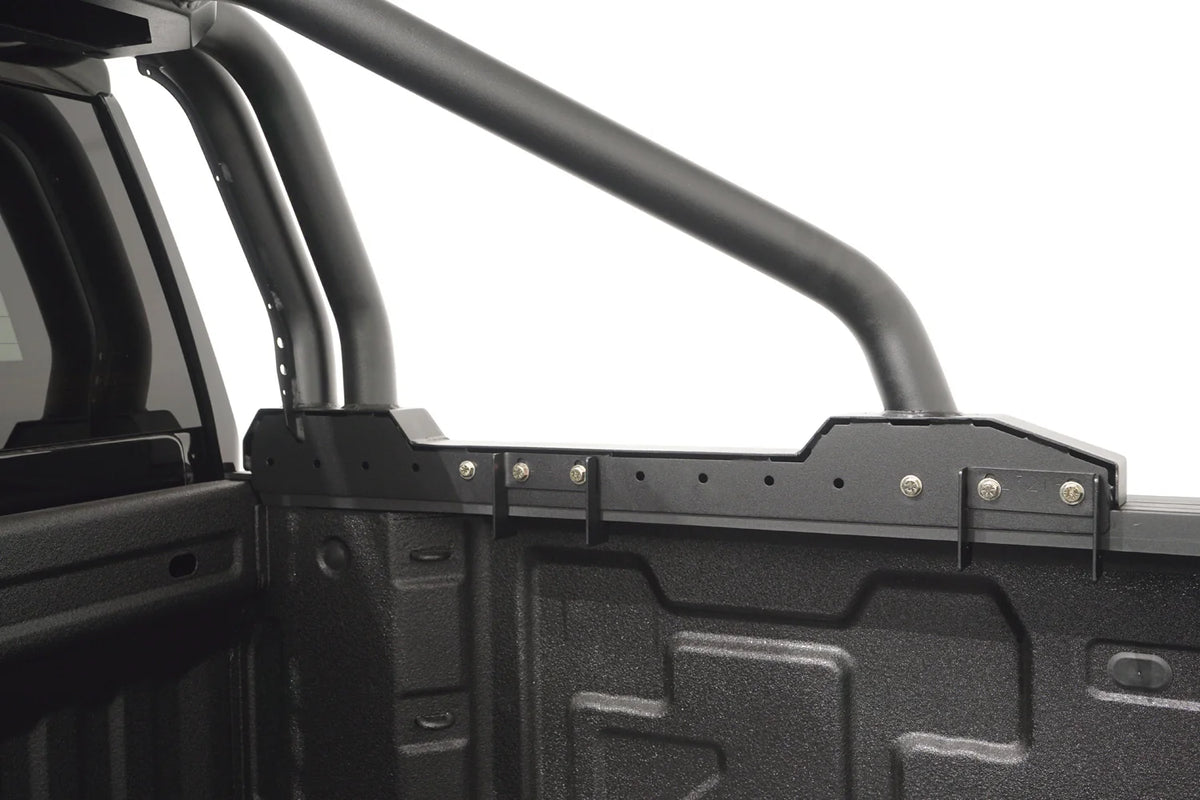 Close-up of the Fab Fours Sport Rack bed rail mount, showing the adjustable clamp brackets, bolt-on hardware and tubular bars over the truck bed
